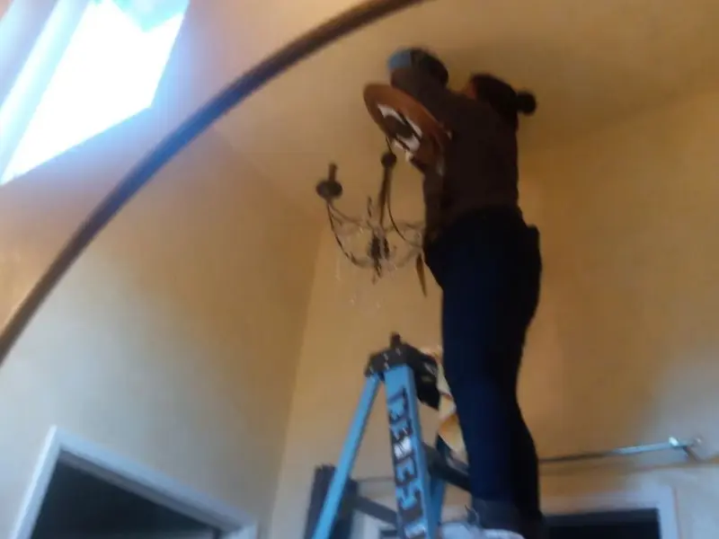 Electrician installing a chandelier in a Floral City residence